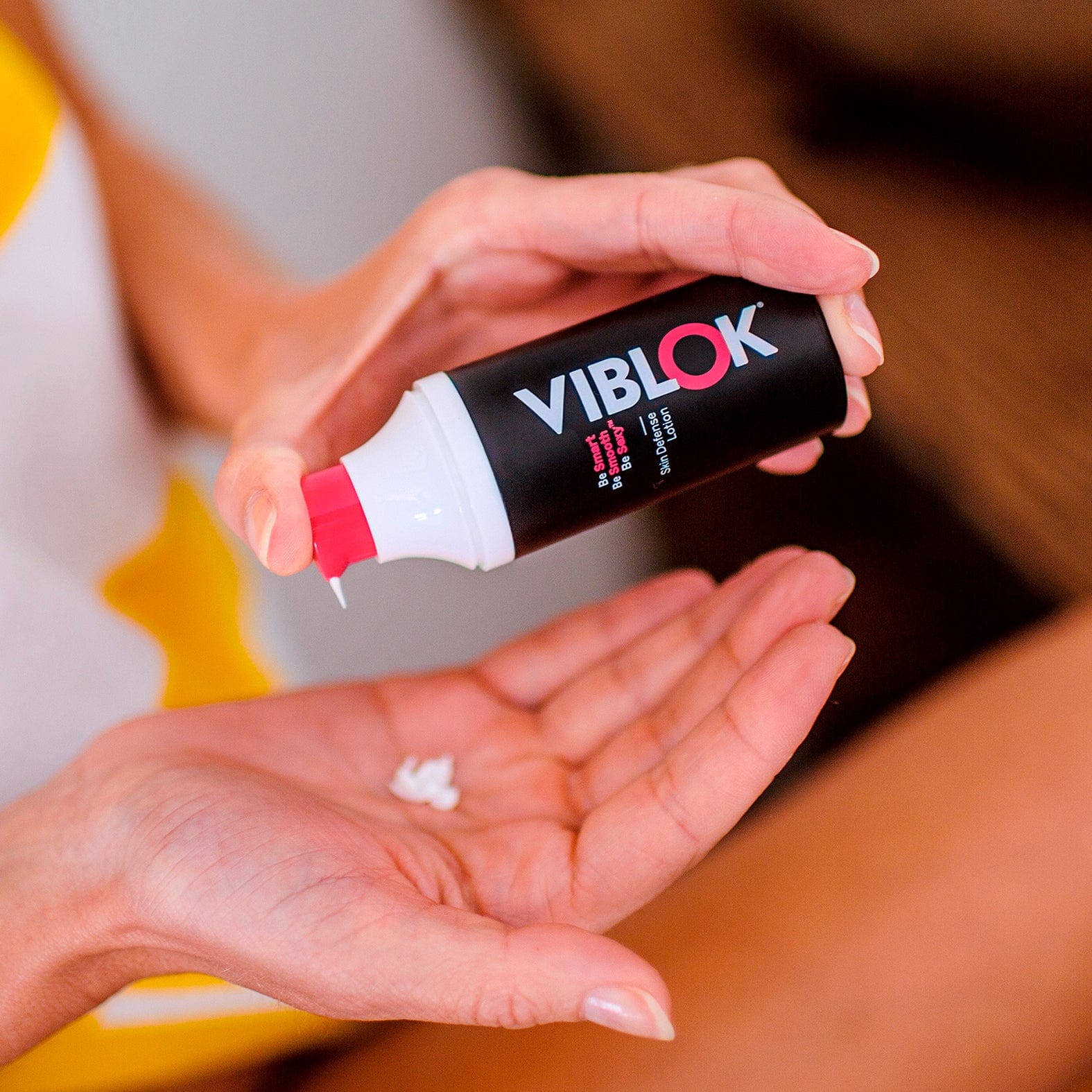 Woman's hands pumping the 30 ml Skin Defense Lotion in her hand